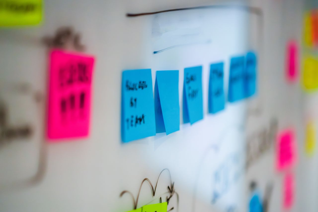 Sticky notes on a whiteboard during a creative brainstorming session in an office.